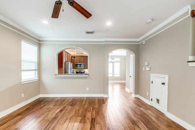 unfurnished living room with a wealth of natural light, ornamental molding, and dark hardwood / wood-style floors