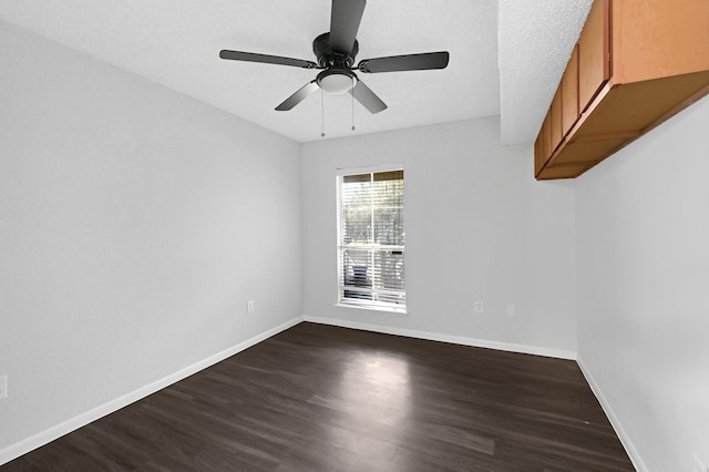 empty room with ceiling fan and dark hardwood / wood-style flooring