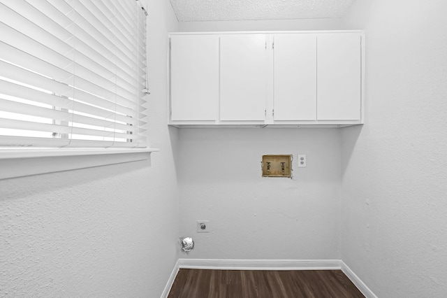 washroom with hookup for a washing machine, a textured ceiling, dark hardwood / wood-style flooring, electric dryer hookup, and cabinets