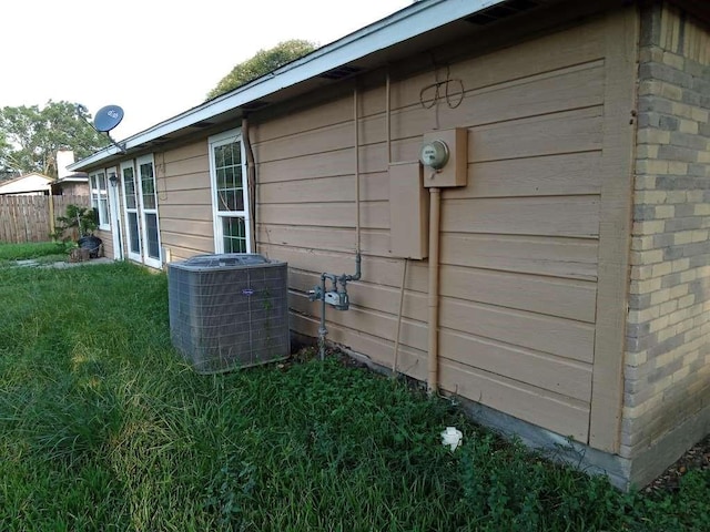 view of property exterior with central AC unit and a yard