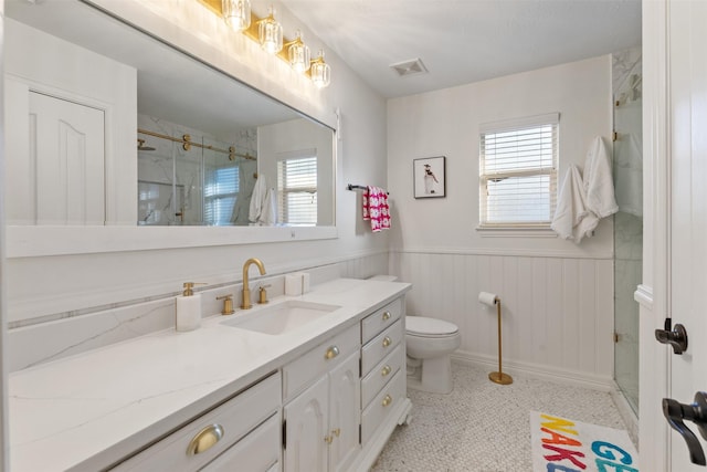 bathroom featuring walk in shower, vanity, toilet, and tile patterned flooring