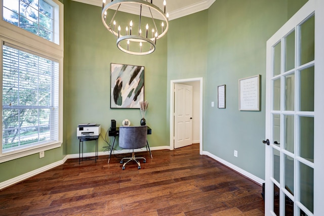 office area with dark wood-type flooring, a chandelier, ornamental molding, and a towering ceiling