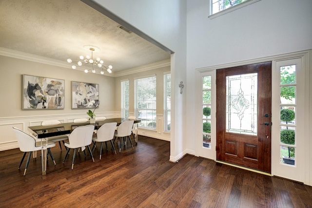 entrance foyer featuring crown molding, dark hardwood / wood-style floors, and an inviting chandelier