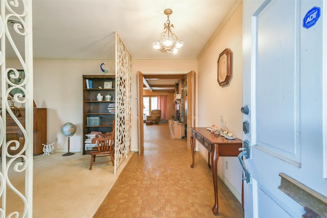 foyer entrance with a chandelier and crown molding