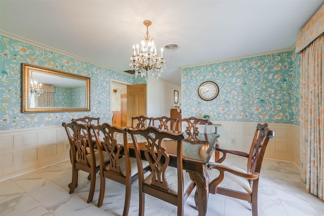 dining room with crown molding and a notable chandelier