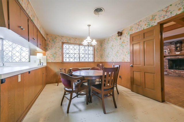 dining area featuring wooden walls and a chandelier