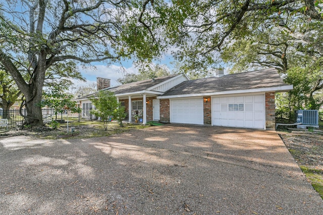 ranch-style home featuring cooling unit and a garage