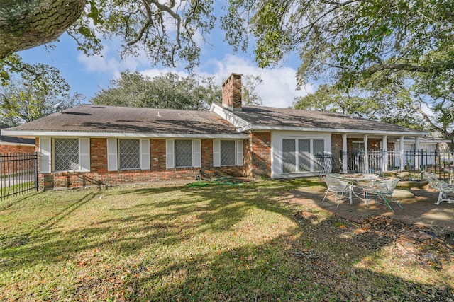 back of house with a patio area and a yard