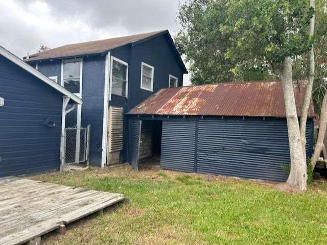 rear view of property featuring a lawn