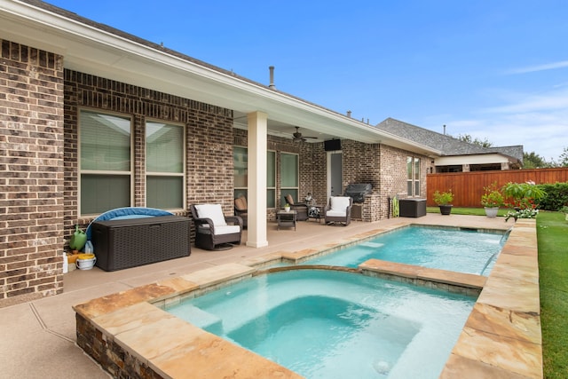 view of pool featuring a pool with connected hot tub, ceiling fan, fence, and a patio