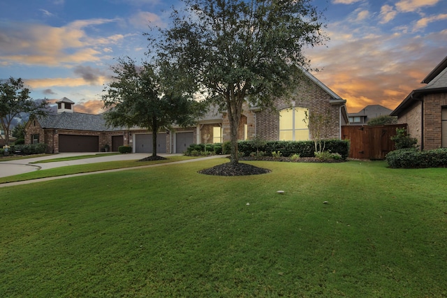 view of front of home featuring concrete driveway, brick siding, a garage, and a front lawn