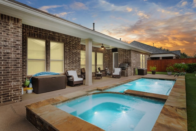 view of pool featuring ceiling fan, a patio area, a pool with connected hot tub, and fence