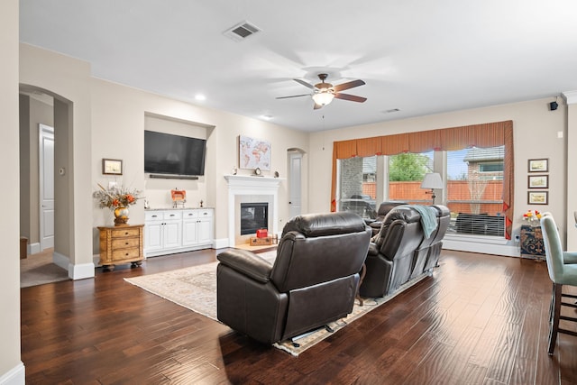 living room with dark hardwood / wood-style flooring and ceiling fan