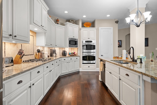 kitchen featuring white cabinetry, appliances with stainless steel finishes, dark wood-type flooring, and pendant lighting