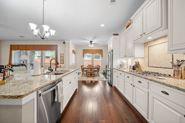 kitchen featuring sink, appliances with stainless steel finishes, hanging light fixtures, an island with sink, and white cabinets