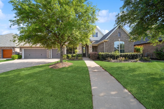 view of front of property featuring a front yard, brick siding, and driveway