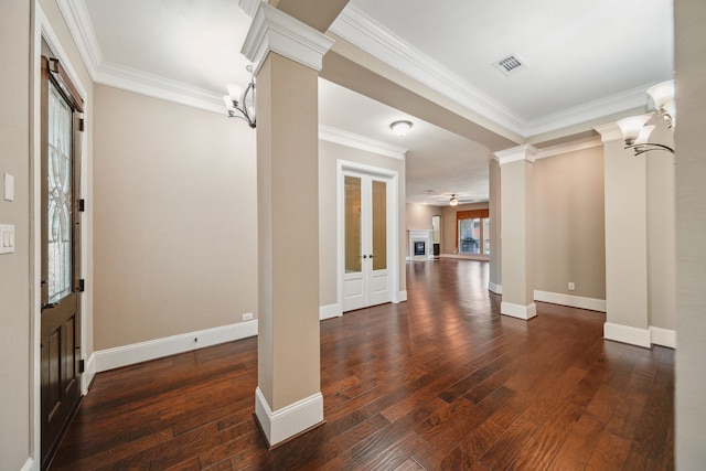 entrance foyer with ornamental molding, visible vents, decorative columns, and dark wood-style floors