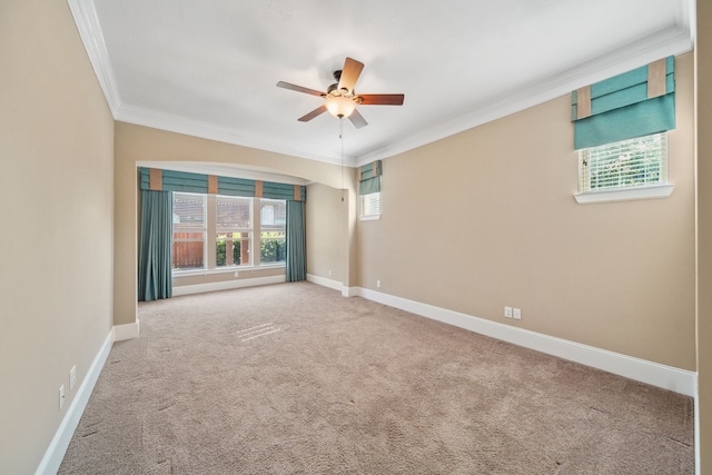carpeted empty room with a ceiling fan, baseboards, and ornamental molding