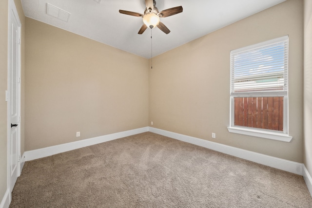 carpeted spare room featuring visible vents, baseboards, and ceiling fan