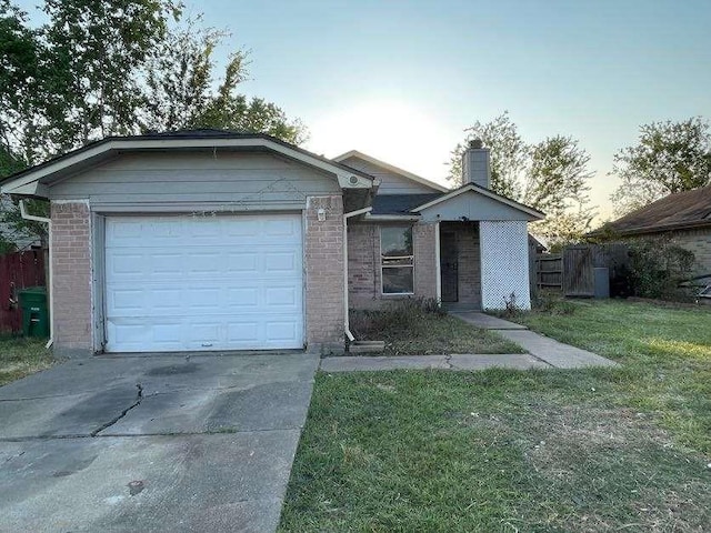 view of front of home with a garage and a lawn