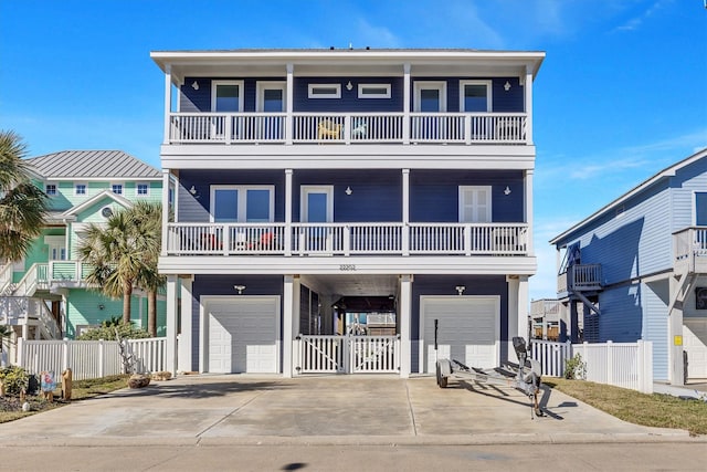 coastal inspired home with driveway, an attached garage, and fence