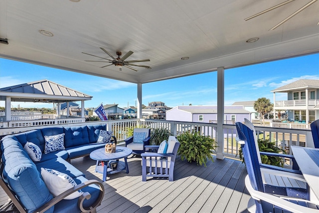 wooden deck with a ceiling fan and an outdoor hangout area