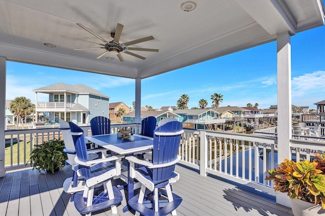 wooden terrace featuring a residential view, outdoor dining area, and ceiling fan