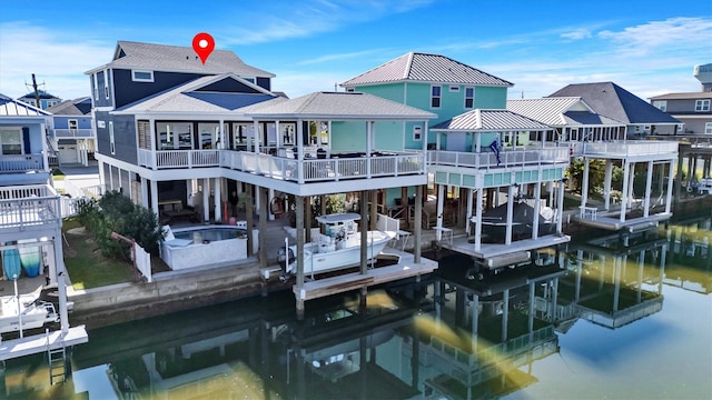 rear view of house featuring roof with shingles, boat lift, and a residential view