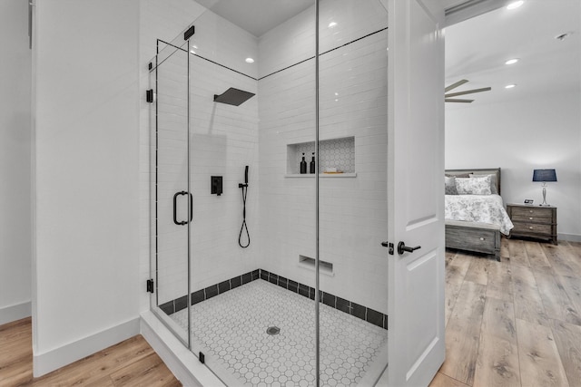 ensuite bathroom with a stall shower, baseboards, wood finished floors, ensuite bathroom, and recessed lighting