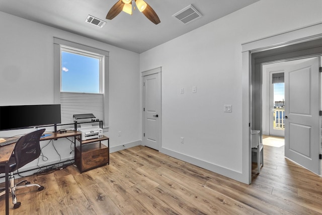 office area featuring a ceiling fan, baseboards, visible vents, and wood finished floors