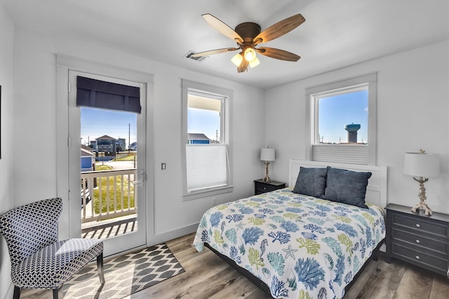 bedroom with access to outside, multiple windows, visible vents, and wood finished floors