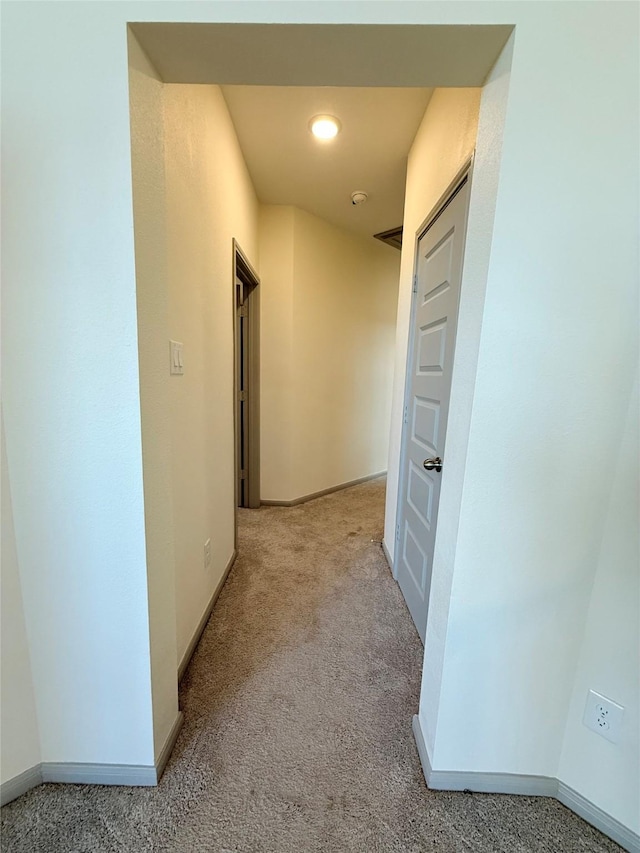 hallway featuring light colored carpet