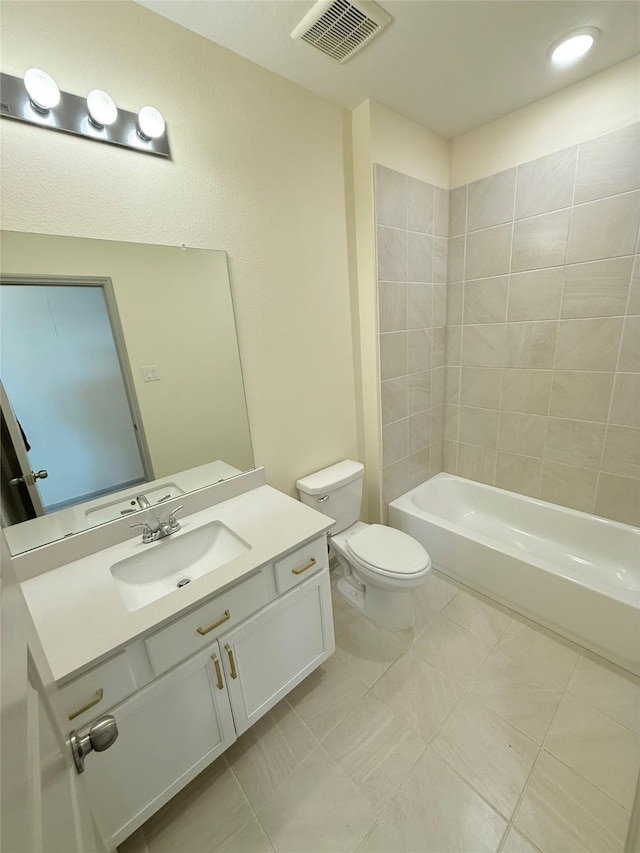 full bathroom with toilet, vanity, and tiled shower / bath