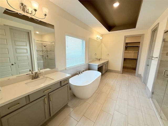 bathroom with vanity, a tray ceiling, and shower with separate bathtub