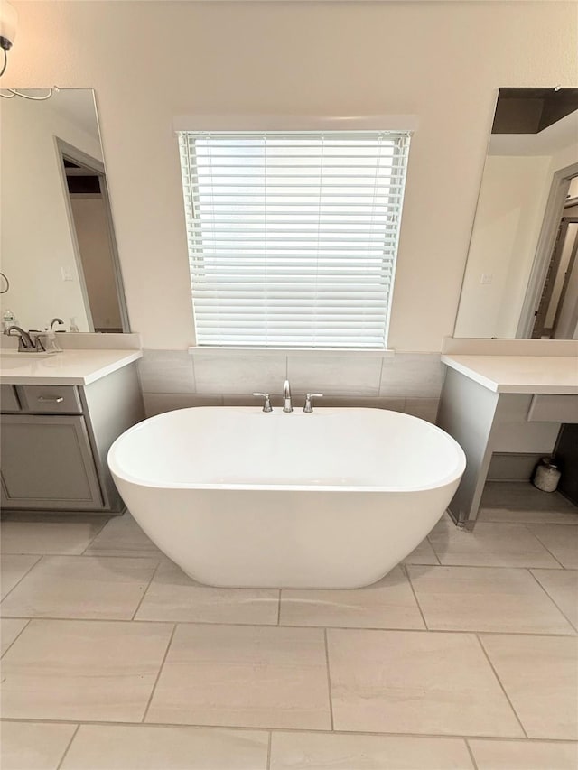 bathroom featuring a healthy amount of sunlight, a bathtub, and vanity