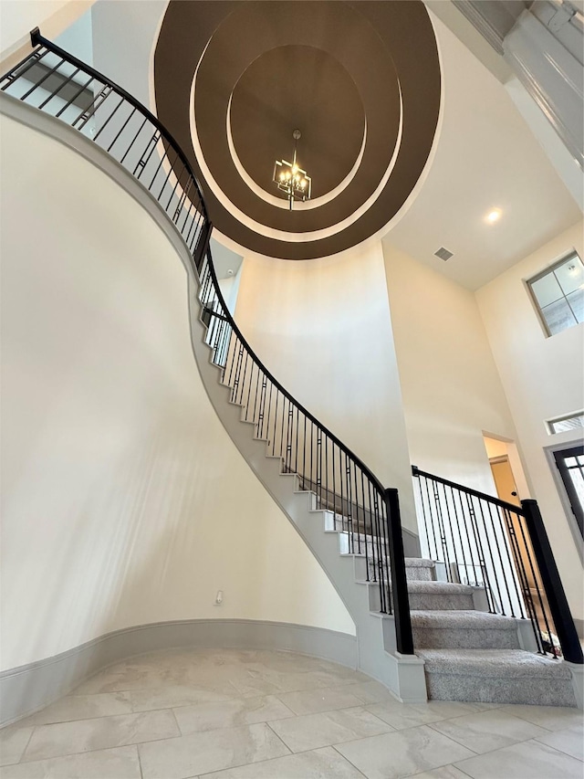 stairs featuring a high ceiling and an inviting chandelier