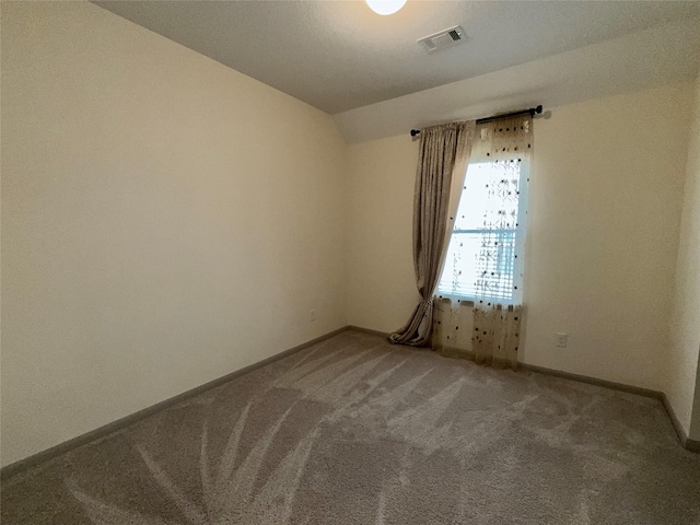 unfurnished room with baseboards, visible vents, carpet flooring, and vaulted ceiling