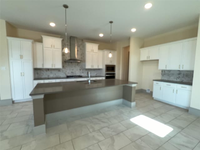 kitchen featuring tasteful backsplash, dark countertops, wall chimney range hood, and recessed lighting