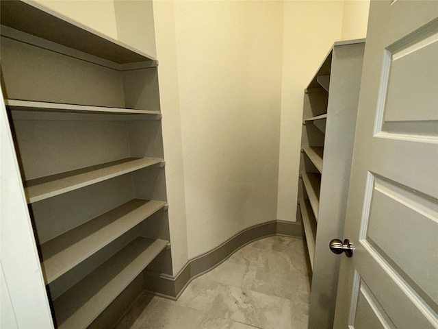 walk in closet with marble finish floor