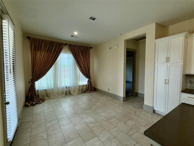 spare room with baseboards, visible vents, and recessed lighting