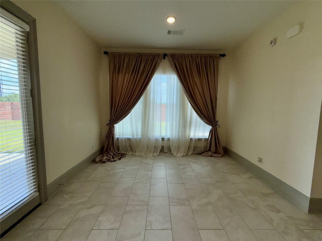 unfurnished room with visible vents and baseboards