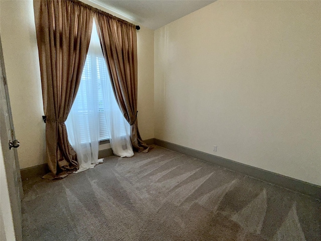 carpeted empty room with baseboards