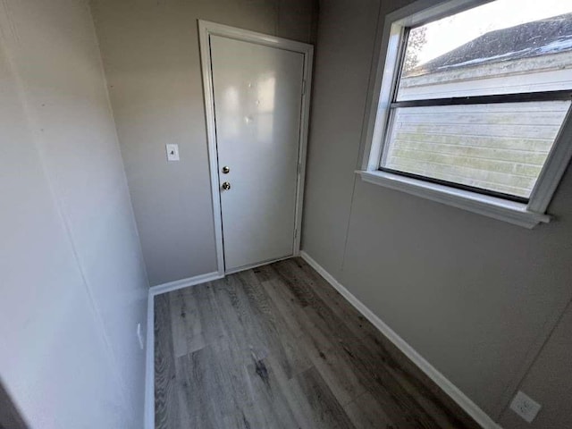 doorway with wood finished floors and baseboards