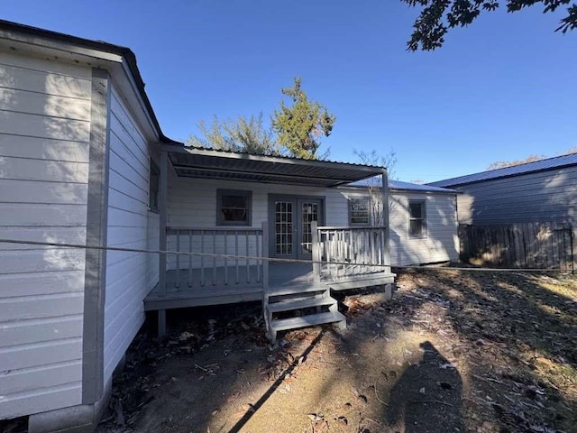 rear view of house featuring fence and a wooden deck