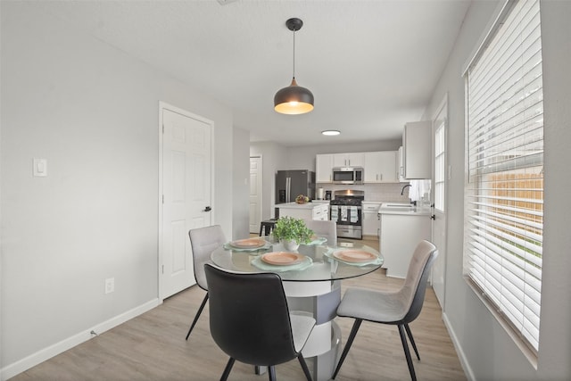 dining area featuring sink and light hardwood / wood-style floors