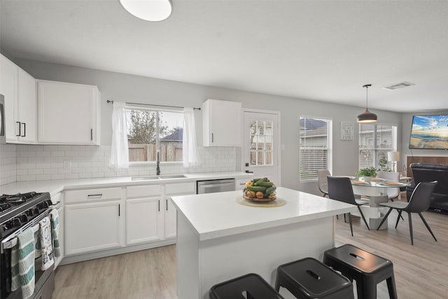 kitchen featuring sink, white cabinetry, dishwasher, and black gas range