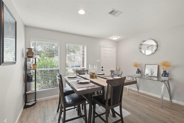 dining space with wood-type flooring and plenty of natural light