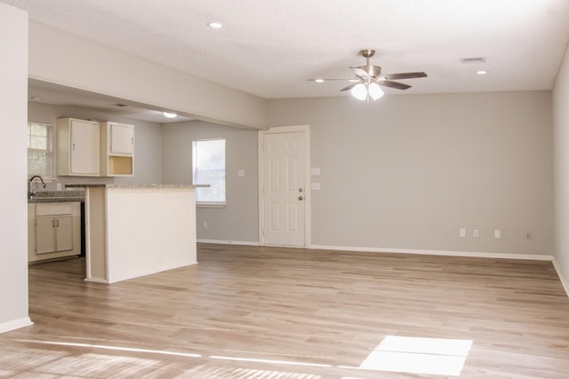 kitchen featuring ceiling fan, a textured ceiling, and light hardwood / wood-style floors