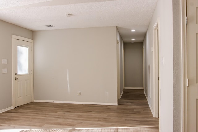 entryway featuring a textured ceiling and light hardwood / wood-style floors