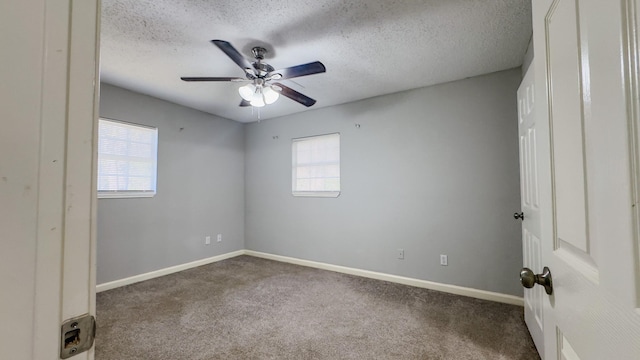 carpeted spare room featuring ceiling fan, plenty of natural light, and a textured ceiling